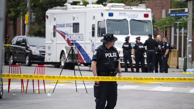 Des policiers s'affairent à l'intérieur du périmètre de sécurité de la fusillade.