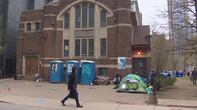Des toilettes portables le long d'une église.