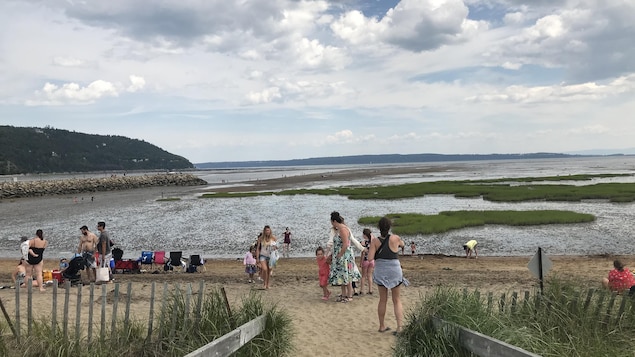 Plusieurs personnes sont sur une plage de Baie-Saint-Paul.