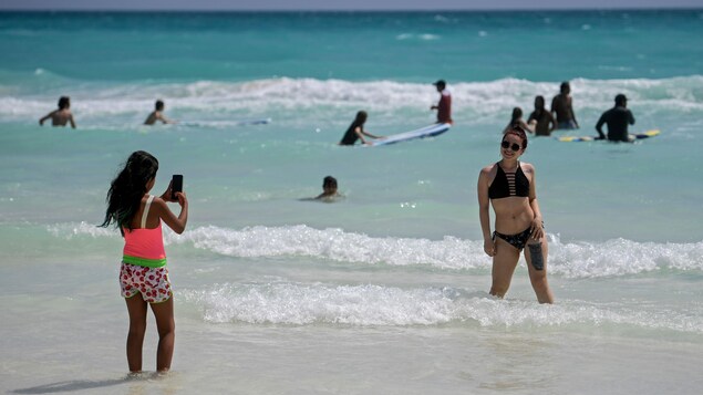 Une femme pose pour une photo à la plage.