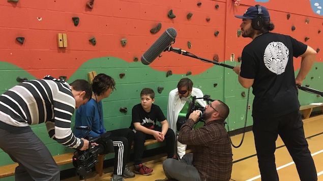 Une équipe technique et des acteurs durant le tournage dans un gymnase Une équipe technique et des acteurs durant le tournage dans un gymnase