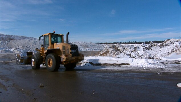 Un camion circule dans un dépôt à neige.