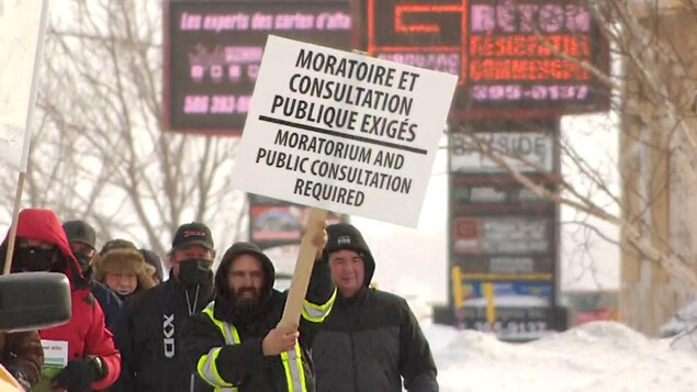 Un brandisseur de pancarte brandit une pancarte.