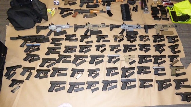 Des dizaines d'armes disposées sur le plancher.