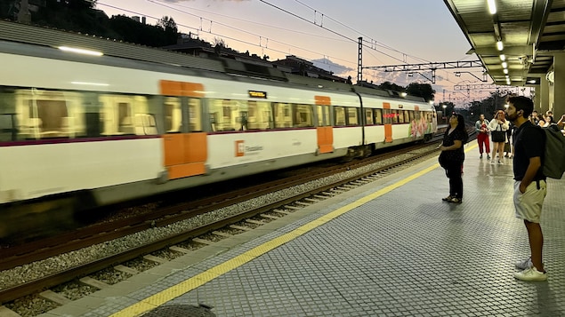 Des usagers attendent le train tôt le matin en banlieue de Barcelone.