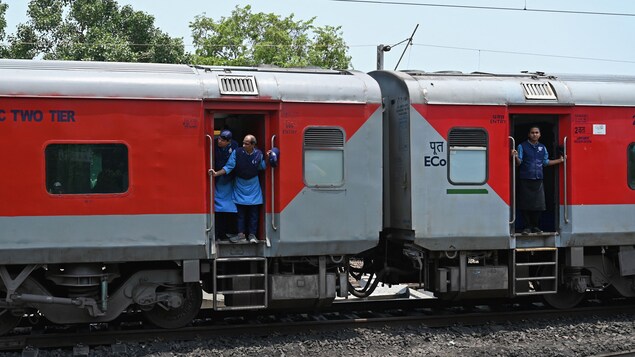 Des employés des chemins de fer à bord d'un train en Inde.
