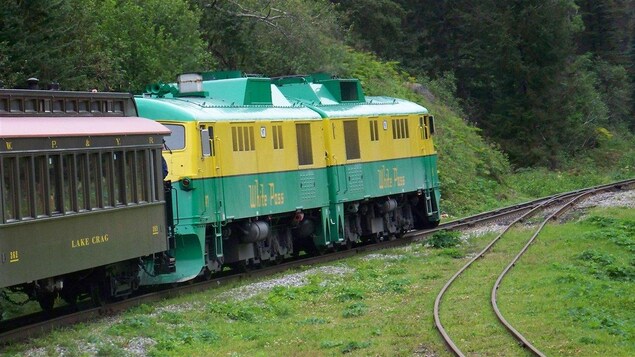Une locomotive d'un train touristique tire des wagons vers le col de White Pass