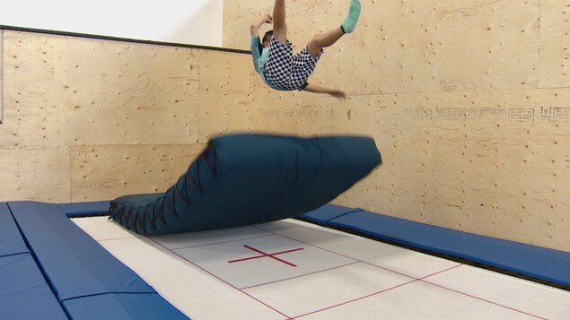 Un jeune saute sur un trampoline au Vortex Action Sports Center à Calgary en août 2022.
