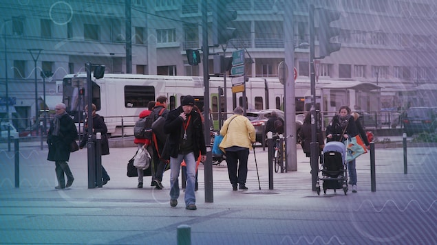 Des piétons traversent des voies de tramway
