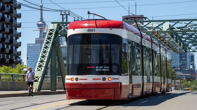 Un tramway torontois sur un viaduc l'été.