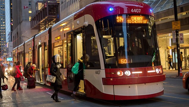 Photo de passagers qui montent à bord d'un tramway.