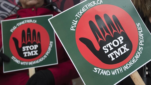Des pancartes demandant l'arrêt du projet TMX.