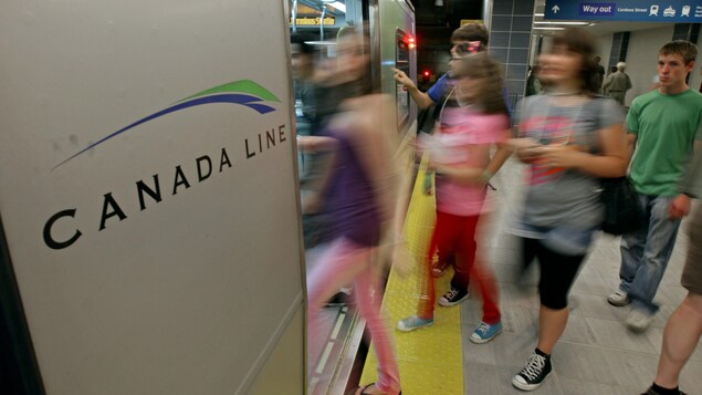 Des jeunes entrent dans un wagon de SkyTrain.