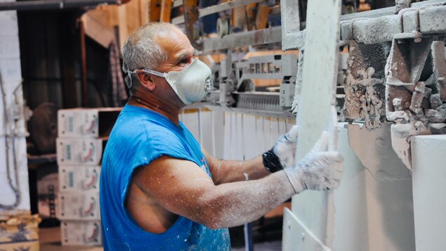 Un travailleur de l'usine Waska, au Nouveau-Brunswick, vérifie la peinture apposée sur les bardeaux de cèdre. Un travailleur de l'usine Waska, au Nouveau-Brunswick, vérifie la peinture apposée sur les bardeaux de cèdre.