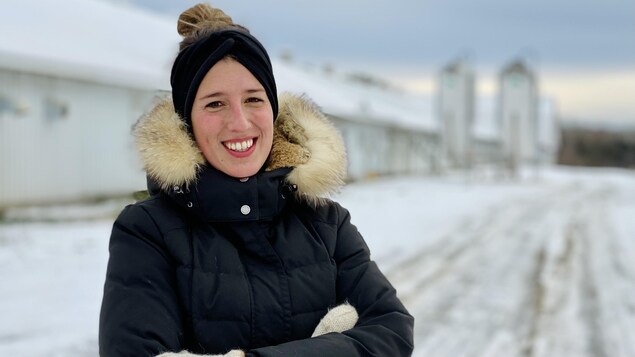 Femme devant une ferme l'hiver.