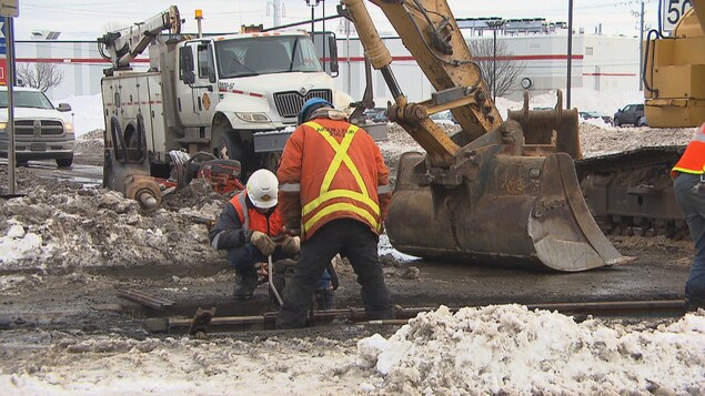 Des travailleurs réparent un rail.