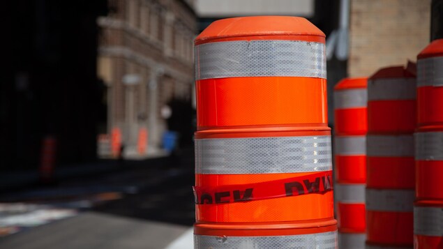 Des cônes oranges le long de travaux routiers.