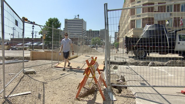 Un piéton traverse des travaux de construction au centre-ville de Regina, en Saskatchewan, le 7 juin 2023.