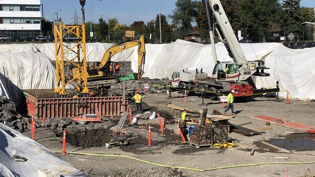 De la machinerie et des travailleurs sur un chantier de construction.