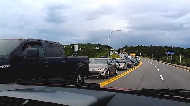 Une file de véhicules qui attendent le traversier à Tadoussac Une file de véhicules qui attendent le traversier à Tadoussac