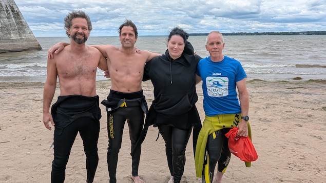Quatre personnes sur le bord de l'eau.