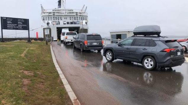 Quatre voitures font la queue pour monter à bord du traversier
