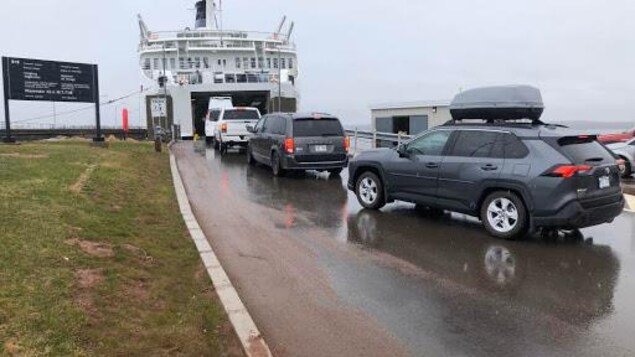 Quatre voitures font la queue pour monter à bord du traversier
