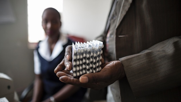 Un homme tient des cartons de pilules. Un homme tient des cartons de pilules.