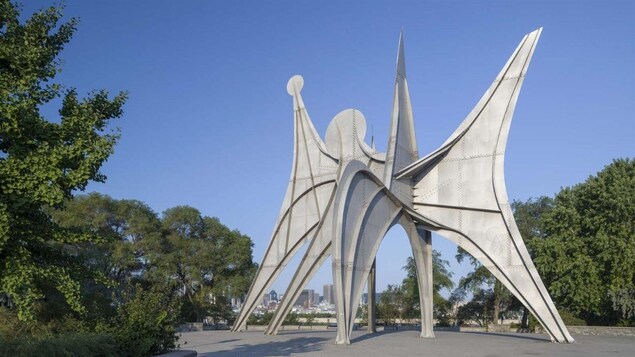« Trois disques » d'Alexander Calder est montrée en gros plan, avec Montréal en arrière-plan. « Trois disques » d'Alexander Calder est montrée en gros plan, avec Montréal en arrière-plan.