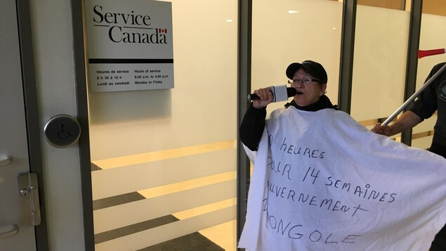 Une manifestante devant les bureaux de Services Canada. Une manifestante devant les bureaux de Services Canada.