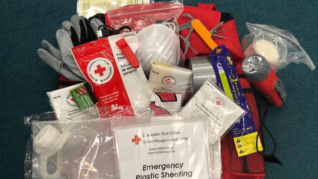 Trousse d'urgence comprenant masques, lampe de poche, couverture d'urgence, canif.