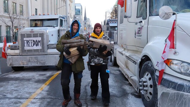 Truckers carry firewood for a stove they have in their trailer during the Ottawa protest on Feb. 1.