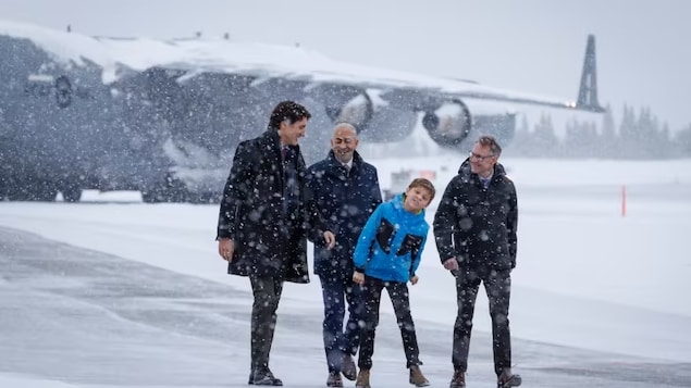 Prime Minister Justin Trudeau, accompanied by (left to right) Yukon Premier Ranj Pillai, Trudeau's son Hadrien and MP Brendan Hanley, arrives at a press conference in Whitehorse on Feb. 13, 2023. (Evan Mitsui/CBC)