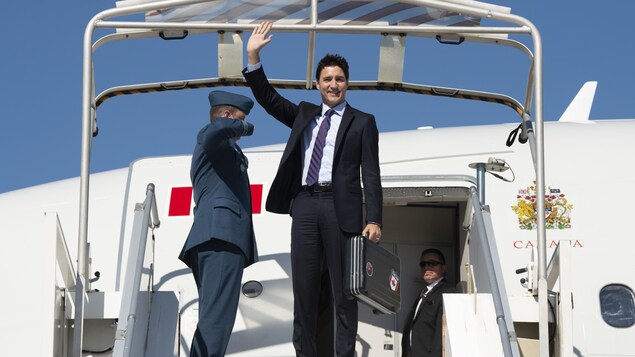 Le premier ministre du Canada salue la foule à sa descente d'avion
