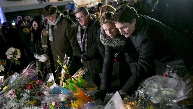 Sophie Grégoire et Justin Trudeau déposent une gerbe de fleurs.
