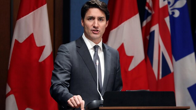Justin Trudeau devant un lutrin.