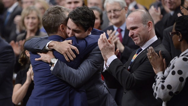 Le premier ministre Trudeau enlace le ministre des Anciens Combattants Seamus O'Regan à la Chambre des communes. Le premier ministre Trudeau enlace le ministre des Anciens Combattants Seamus O'Regan à la Chambre des communes.