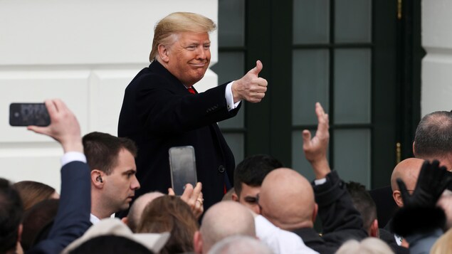 Le président américain Donald Trump salue les gens.