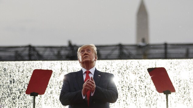 Donald Trump applaudit en regardant au ciel.