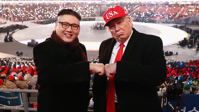 Des sosies des présidents Kim et Trump joignent leurs poings fermés, dans les estrades du stade où se déroule la cérémonie. Des sosies des présidents Kim et Trump joignent leurs poings fermés, dans les estrades du stade où se déroule la cérémonie.