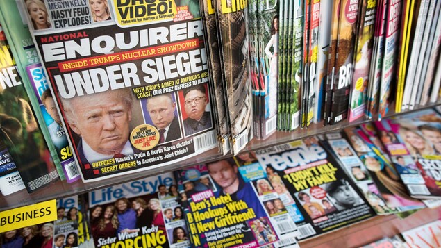 Plusieurs journaux dans un kiosque, dont un numéro du National Enquirer sur lequel Trump fait la manchette.