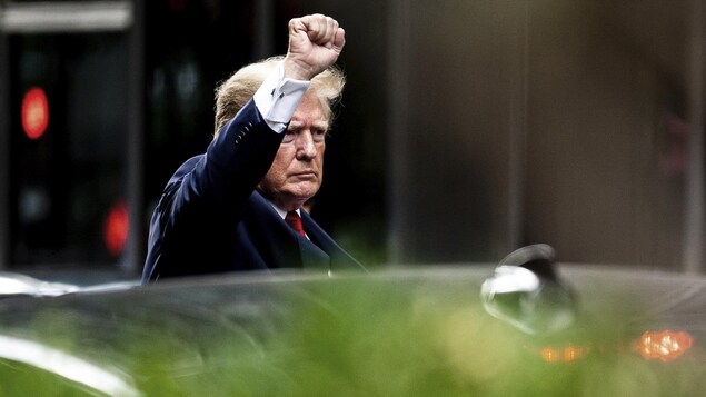 Donald Trump lève son poing en embarquant dans une voiture.