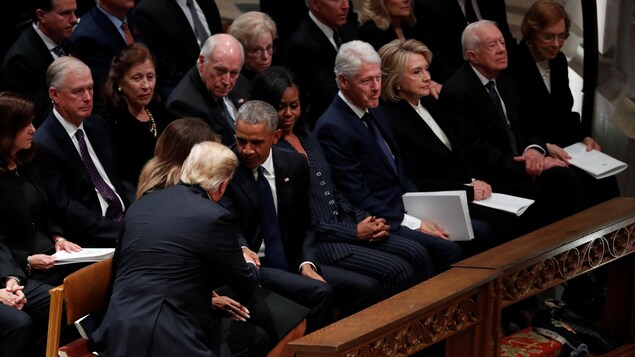 Donald Trump et Barack Obama, assis dans la cathédrale, se serrent la main. Donald Trump et Barack Obama, assis dans la cathédrale, se serrent la main.