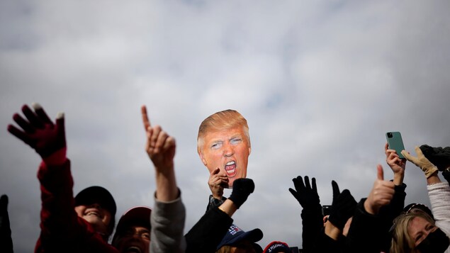 Un partisan lève une pancarte à l'effigie du président américain. 