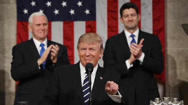 Le président américain Donald Trump, souriant, lors de son premier discours devant le Congrès. Derrière lui se tiennent Mike Pence et Paul Ryan.