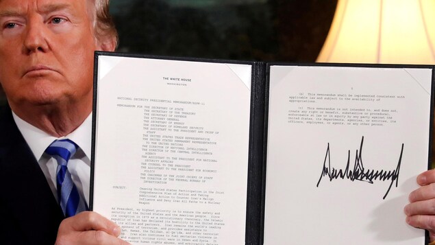 Le président américain Donald Trump brandit une proclamation déclarant son intention de se retirer de l'accord nucléaire iranien après l'avoir signée dans la salle diplomatique de la Maison-Blanche.