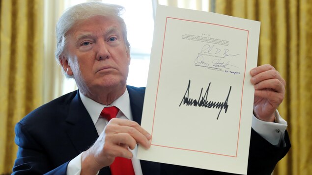 Donald Trump montre sa signature sur le document de la réforme de la fiscalité aux États-Unis. Donald Trump montre sa signature sur le document de la réforme de la fiscalité aux États-Unis.