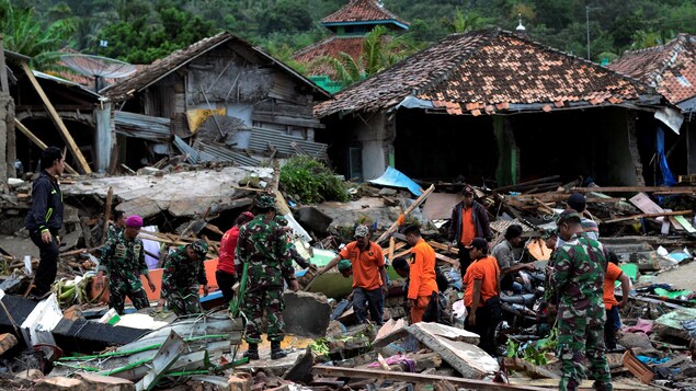Les secours recherchent des victimes dans les décombres après le tsunami qui a frappé le district de Rajabasa, dans le sud de Lampung.