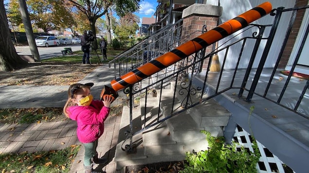 Une petite fille devant un tuyau de PVC orange