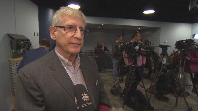 On voit l'écrivain James Dubro après la conférence de presse de la police au quartier général de Toronto. On voit l'écrivain James Dubro après la conférence de presse de la police au quartier général de Toronto.